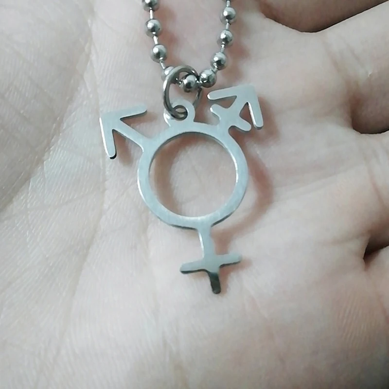 Pendentif symbole transgenre présenté dans la main