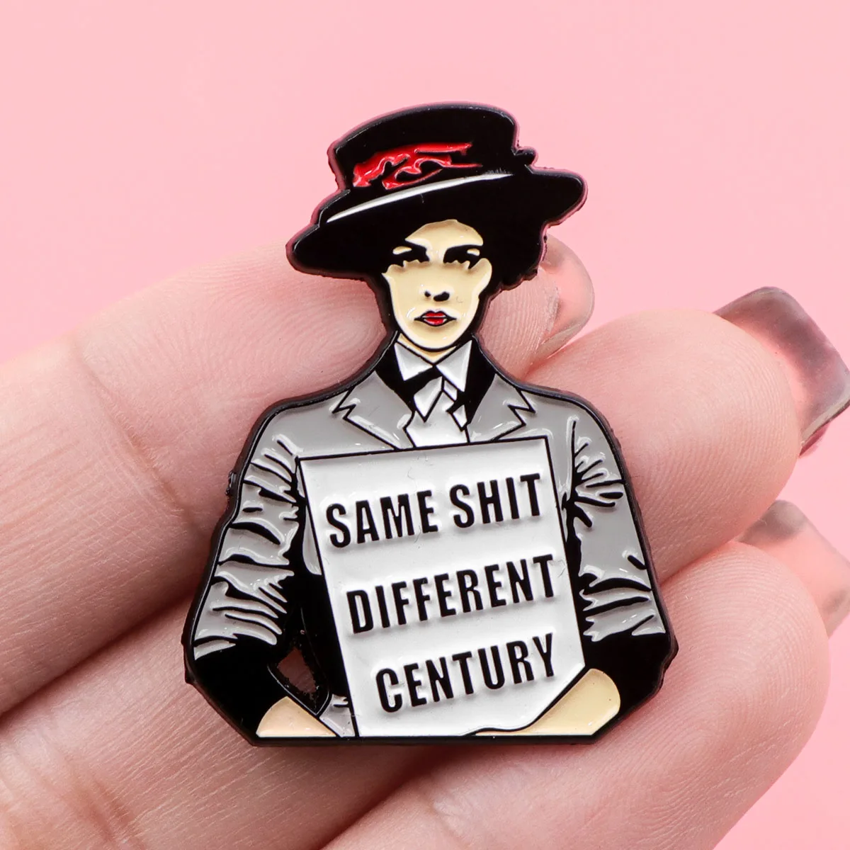 Pin’s féministe présenté dans la main