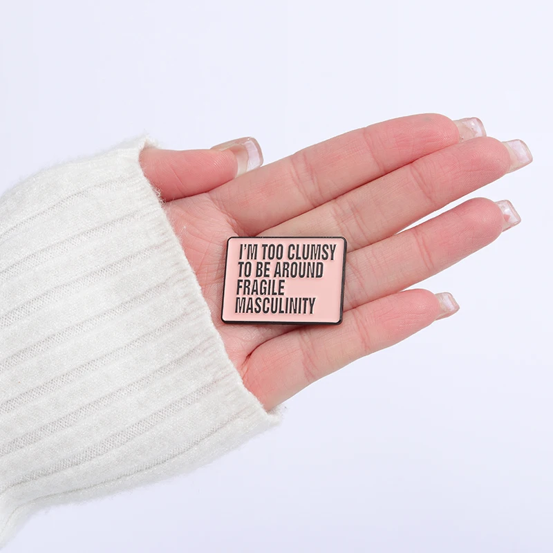 Pin’s Fragile Masculinity présenté dans une main