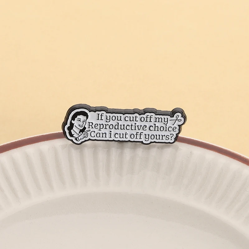 Broche Reproductive Choice présentée sur une assiette