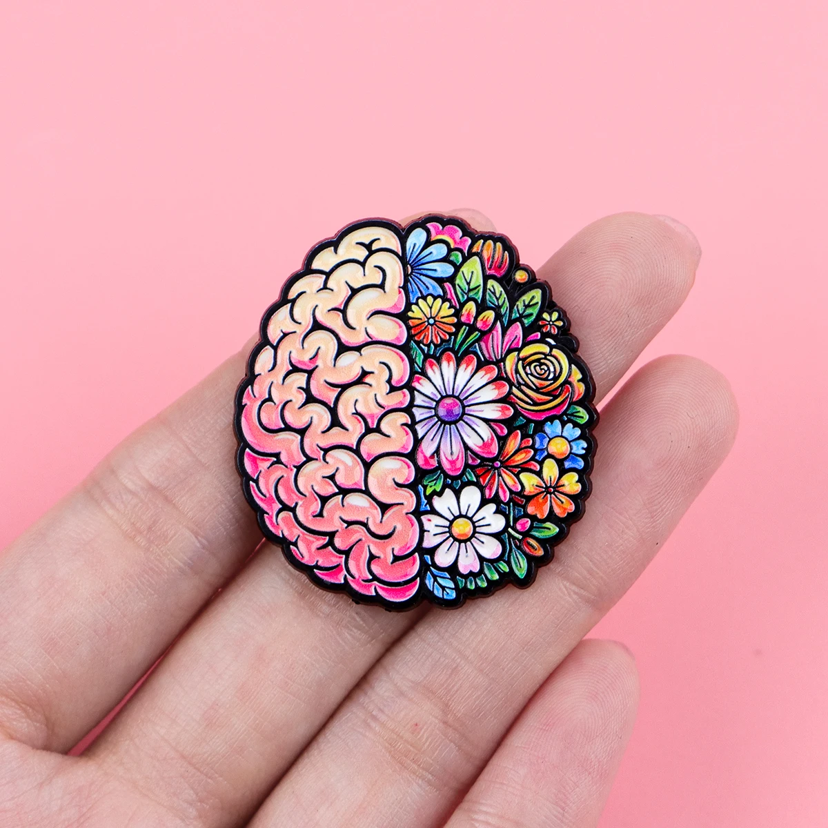 Pin’s santé mentale cerveau fleuri présenté dans une main