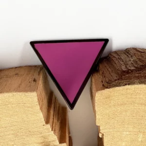 Pin’s triangle rose Pride présenté sur bois