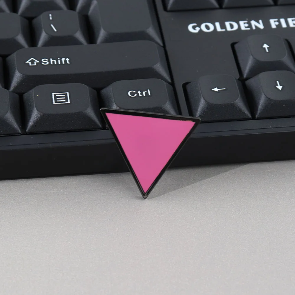 Pin’s triangle rose posé devant un clavier