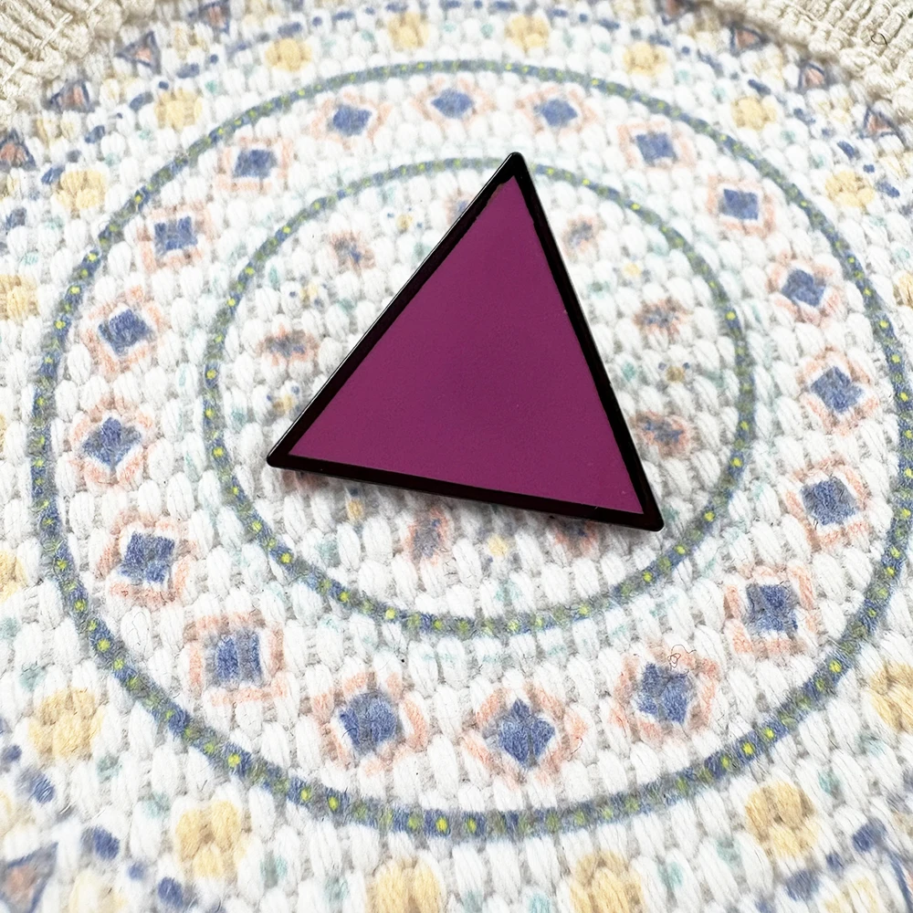 Broche triangle rose sur textile tissé