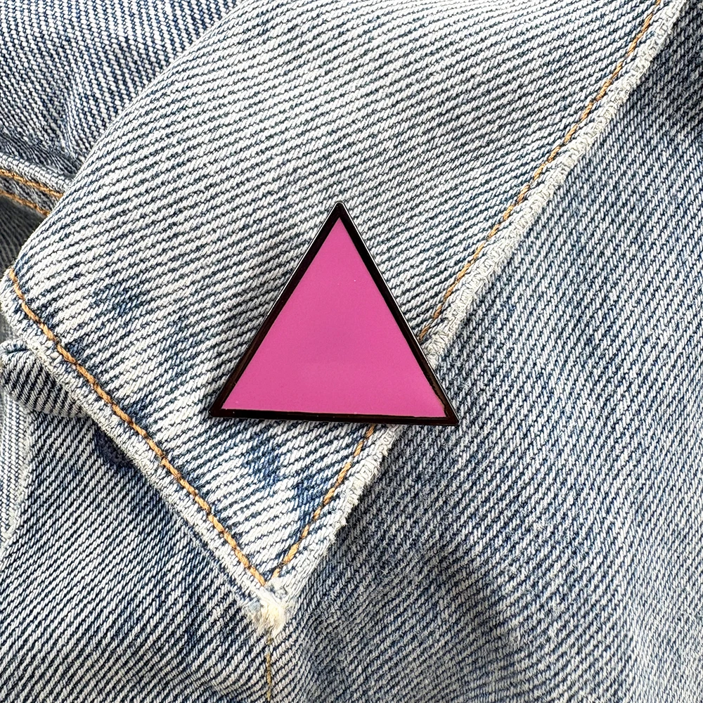 Pin’s triangle rose porté sur une veste en jean