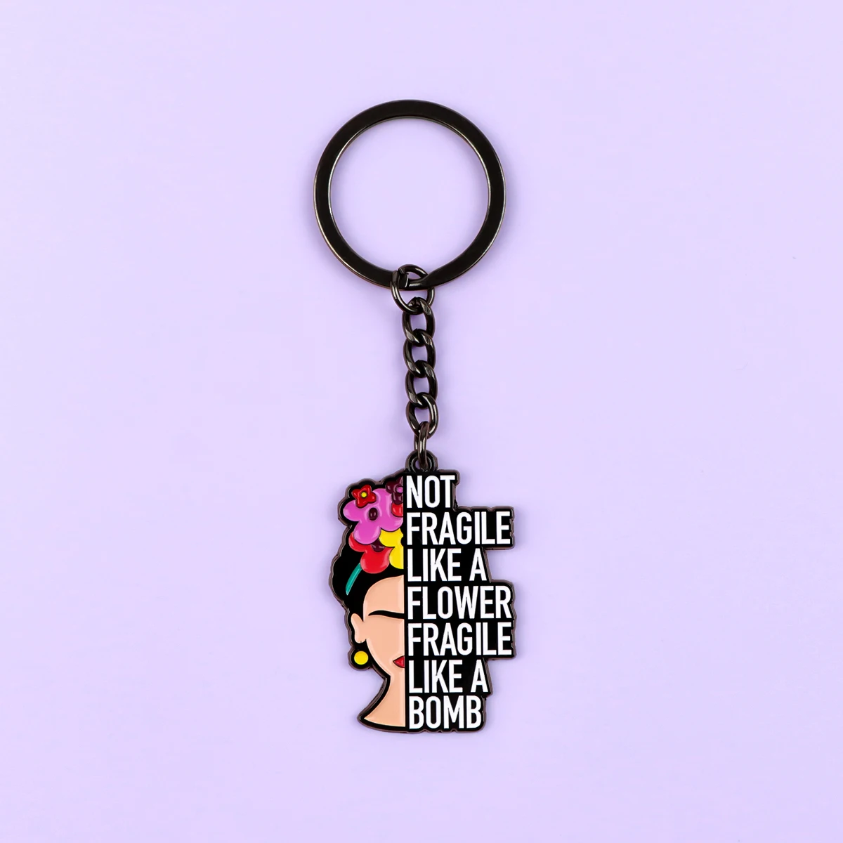 Détail du porte-clés féministe sur fond lilas