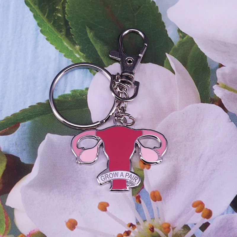Porte-clés utérus émaillé présenté sur une fleur